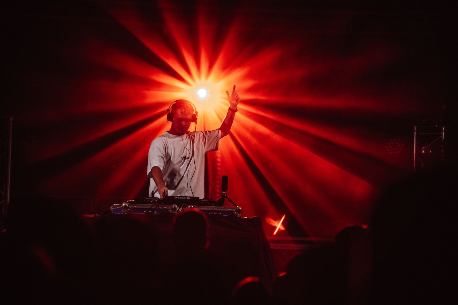 Mike Tunes at the decks under a red starburst light