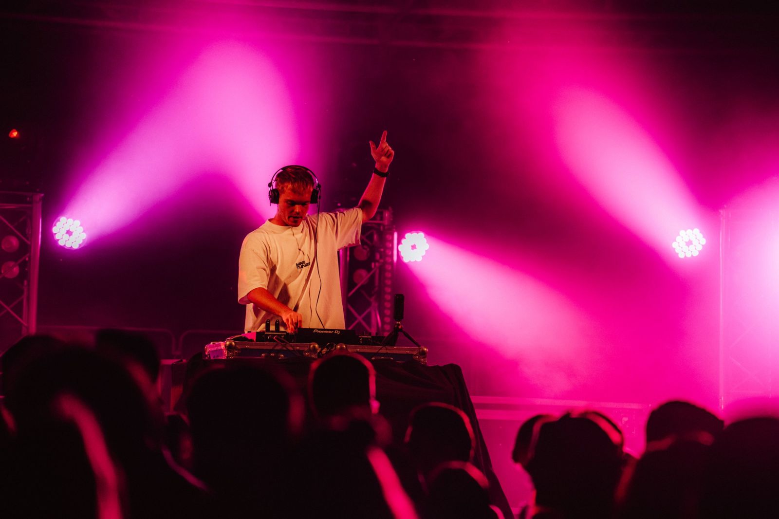 Mike Tunes on stage with pink lights and the crowd in front